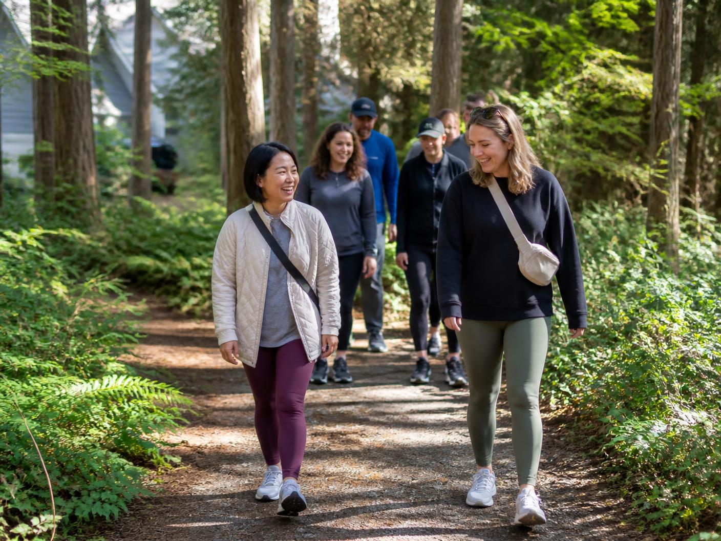Neighbors walking a wooded trail lined with ferns near the home in Hillsboro, Oregon